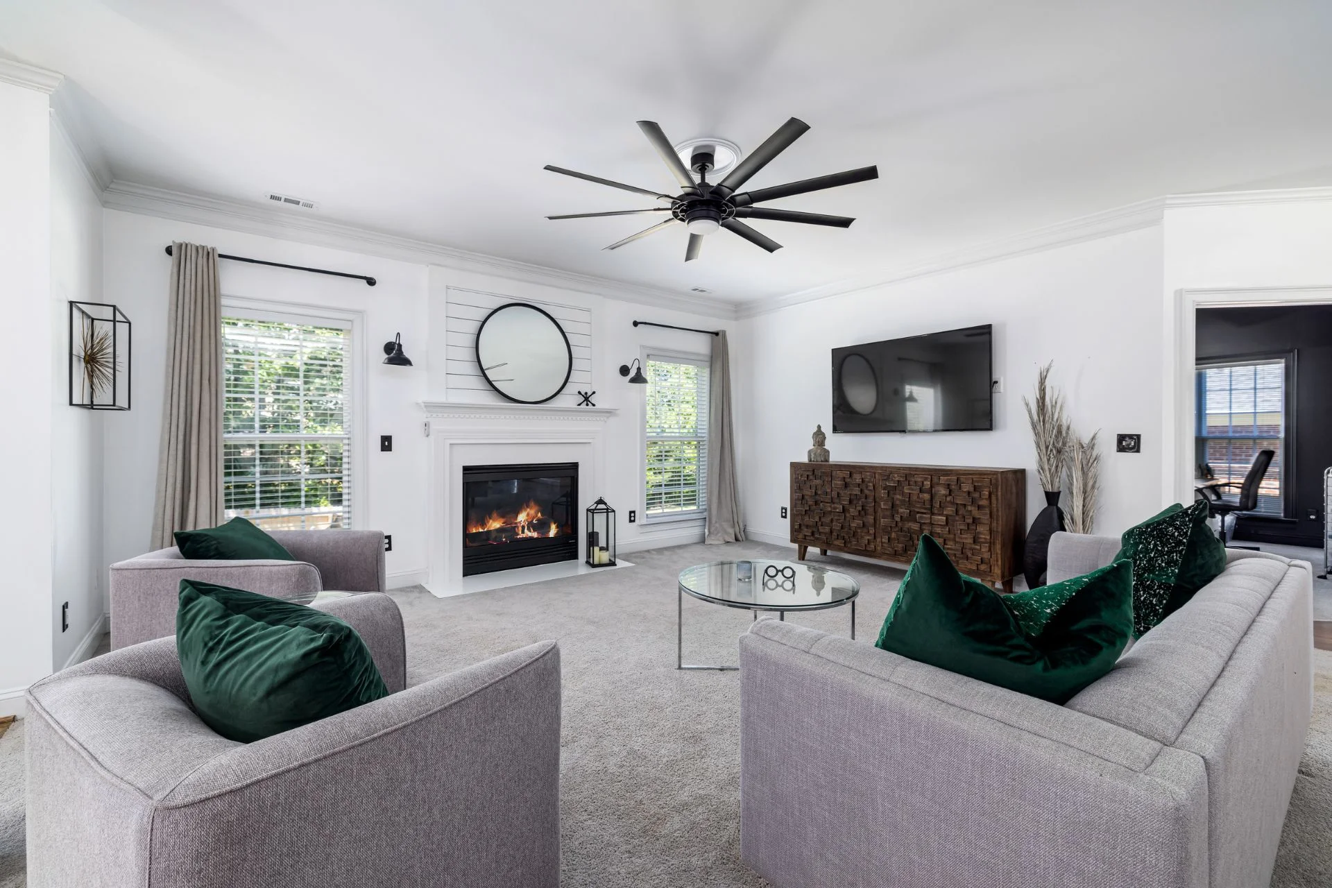 A living room with a fireplace and ceiling fan, undergoing carpet installation.