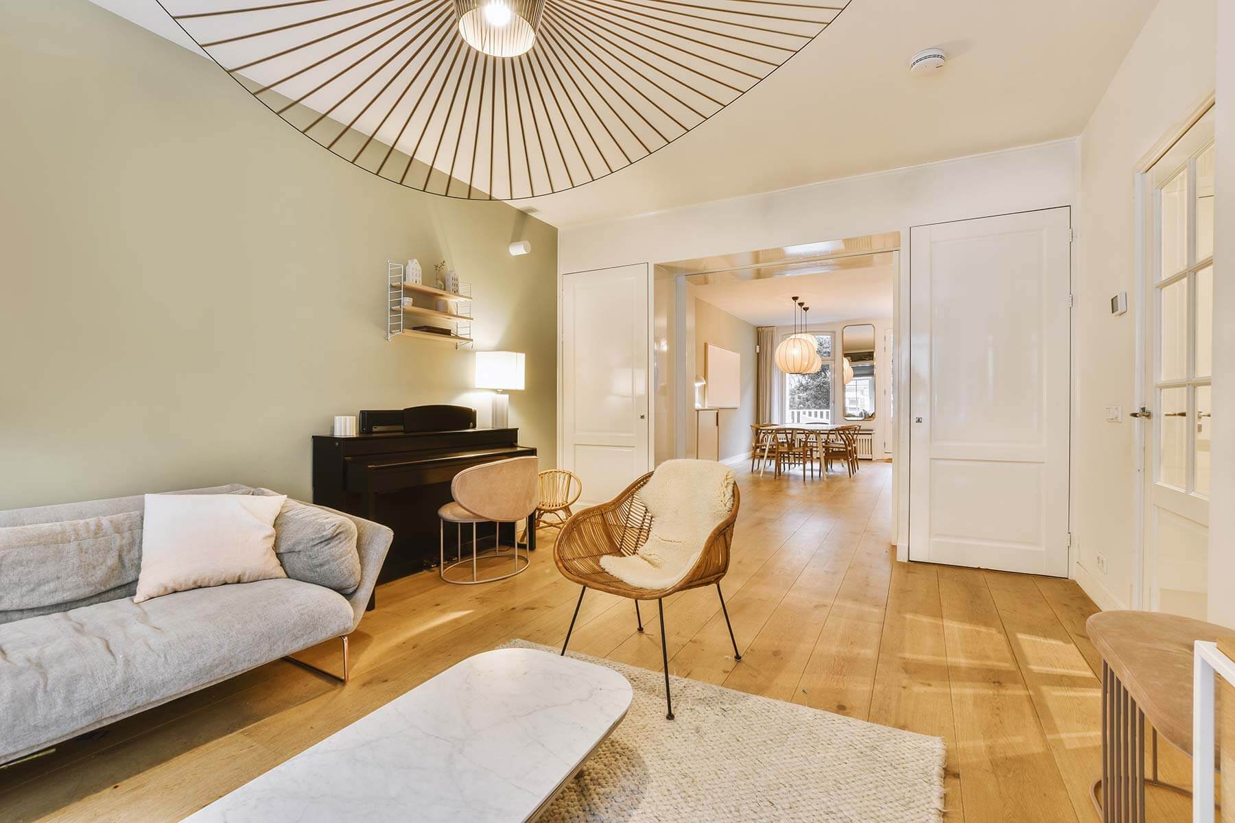 A living room with wooden floors and a chandelier.