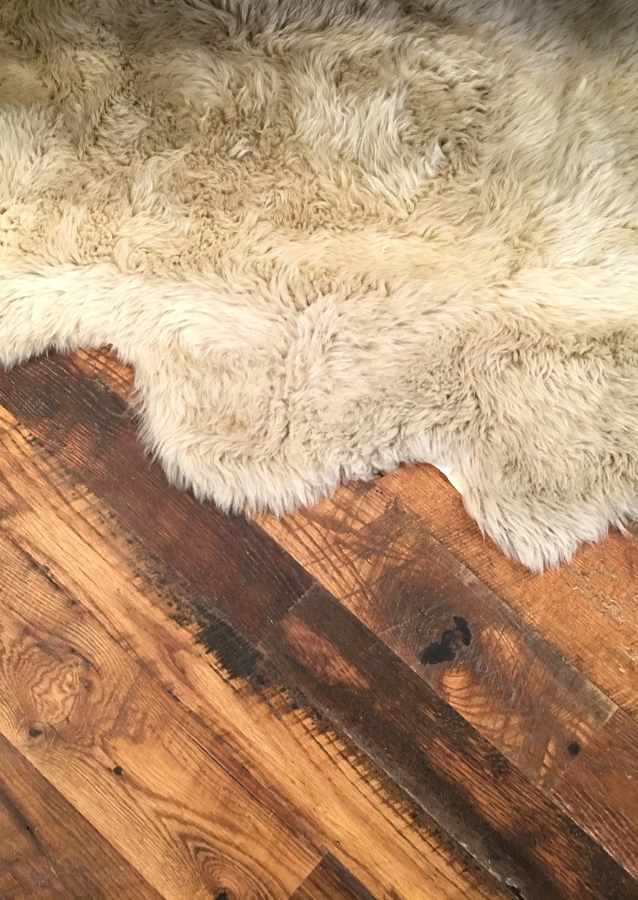 A sheepskin rug on handscraped hardwood flooring.