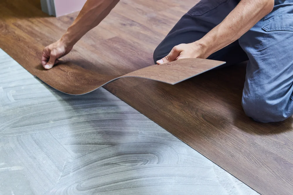 A man installing vinyl flooring.
