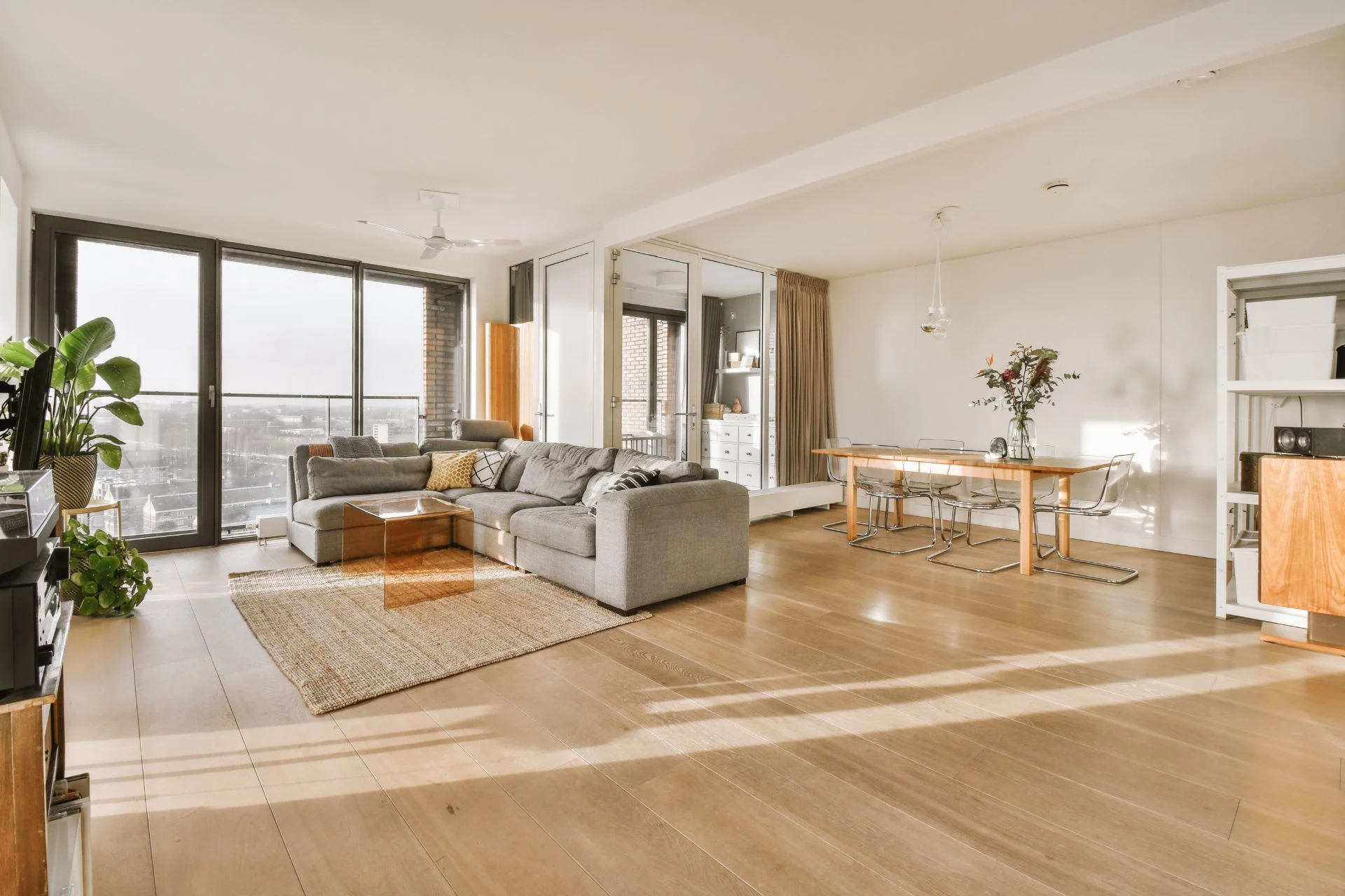 A living room with hardwood flooring and a view of the city.