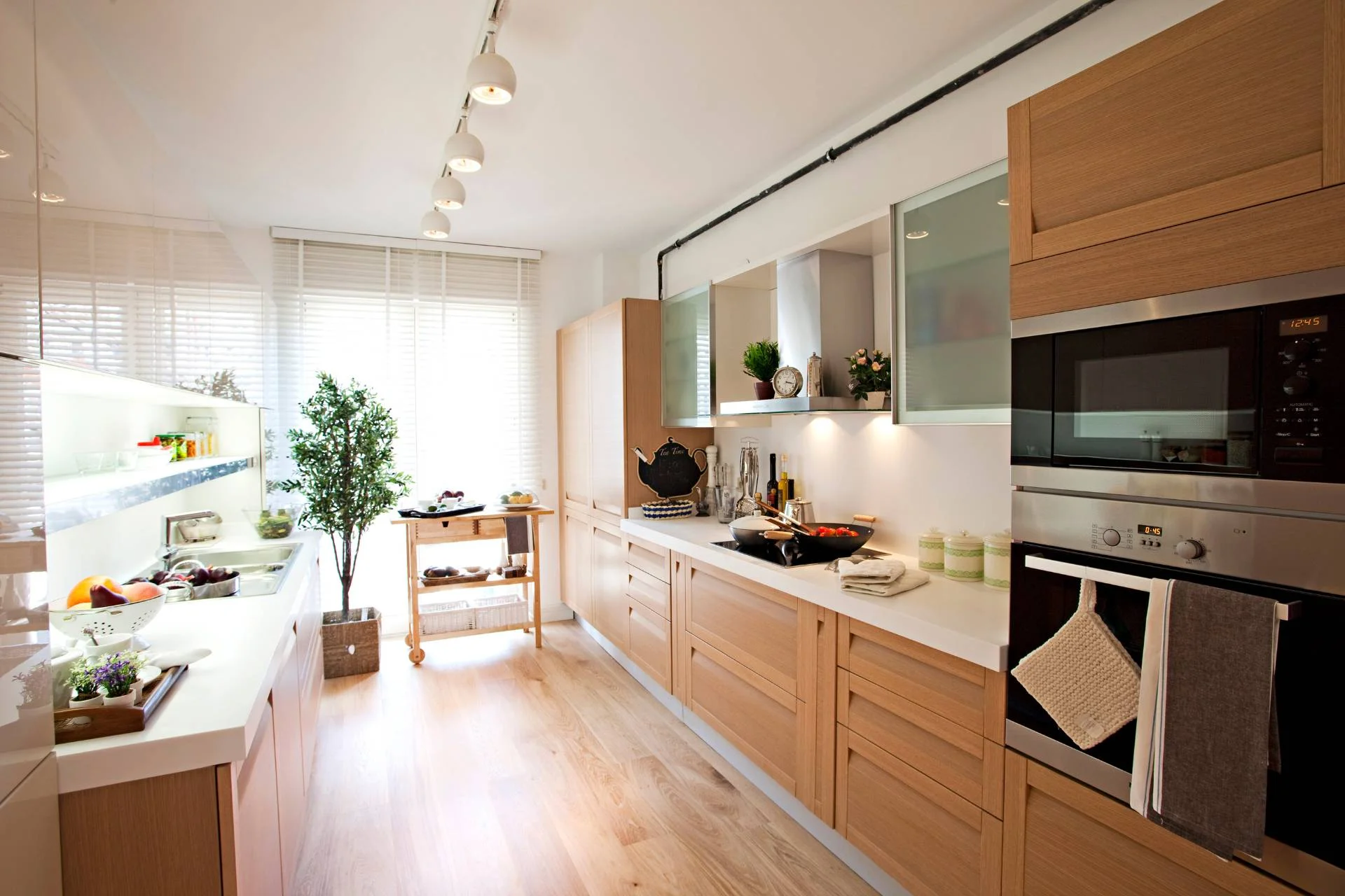 A kitchen with wooden cabinets and vinyl flooring.