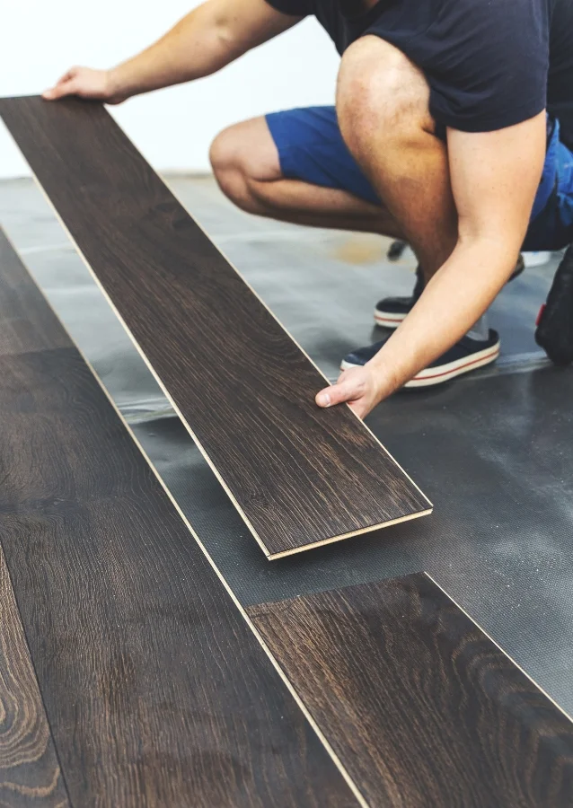 A man is installing laminate flooring.