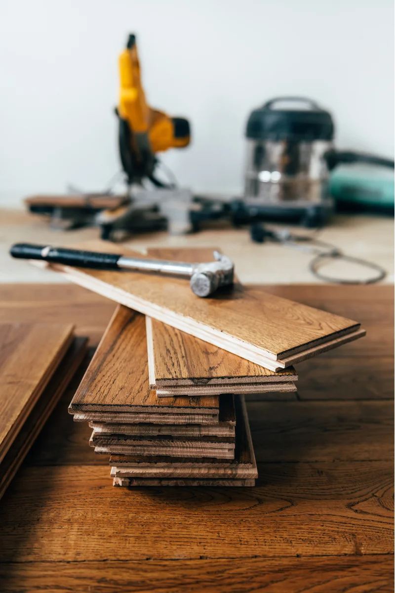 A pile of wood flooring and tools on a Alpharetta Flooring Company table.