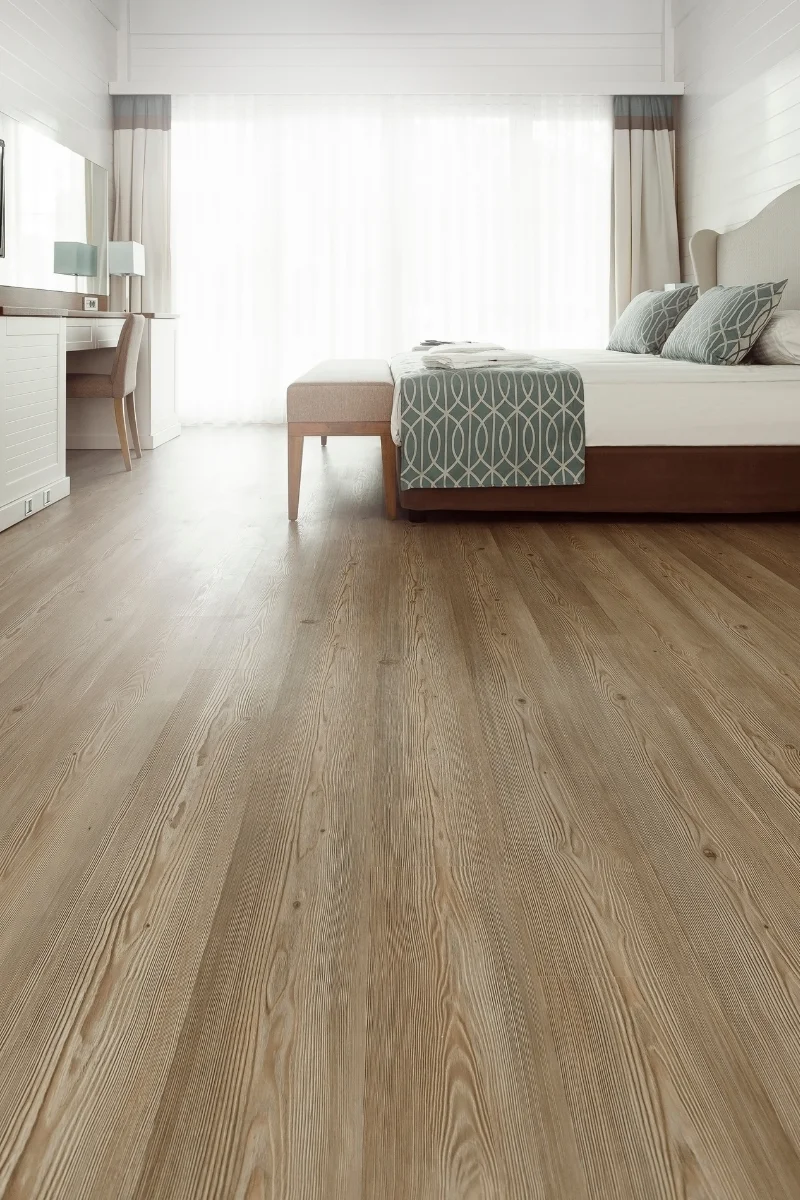 A bedroom with flooring installed by an Alpharetta flooring company and a bed.