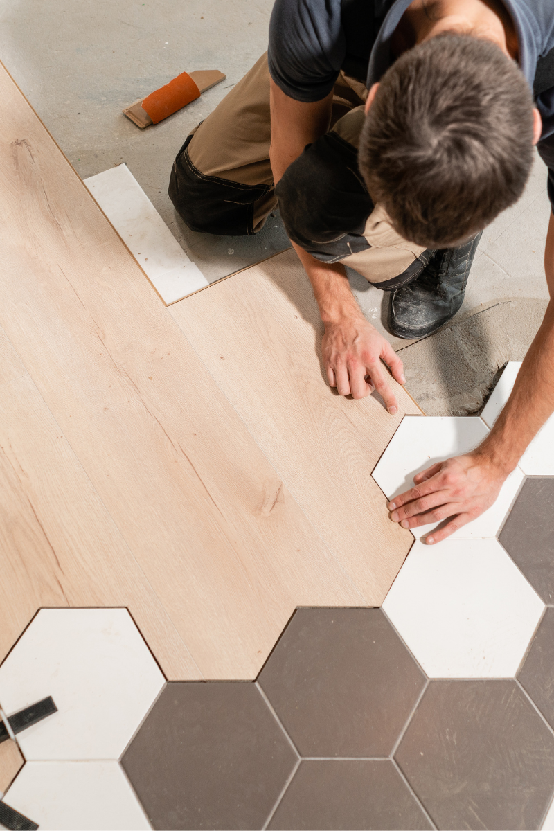 An Austell Flooring Company employee is installing tile on a floor.