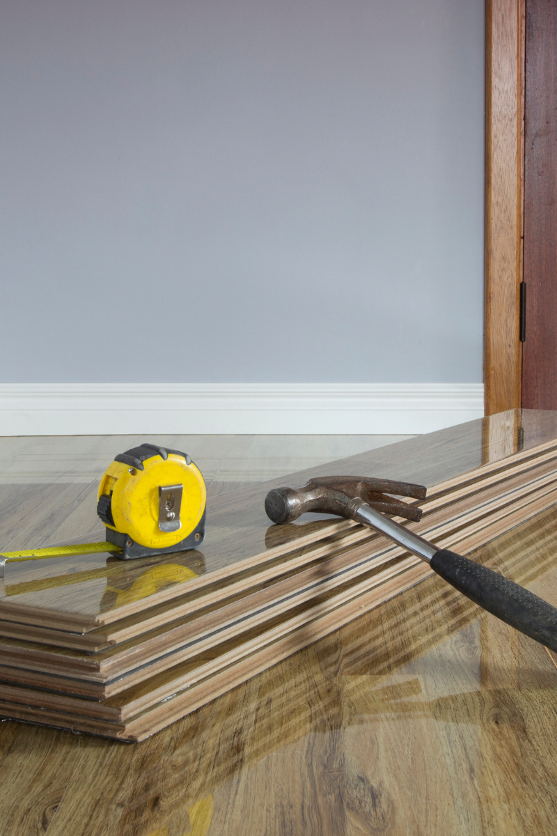 Canton Flooring Services 10 A wooden floor adorned with a yellow tape measure, brought to you by Canton Flooring Company.