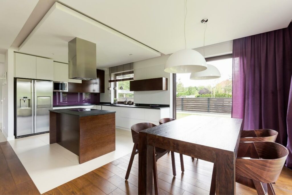 Creating Harmony: Unveiling the Perfect Furniture and Floor Color Combinations 2 A modern kitchen with purple walls and wooden floors, showcasing furniture and floor color combinations.