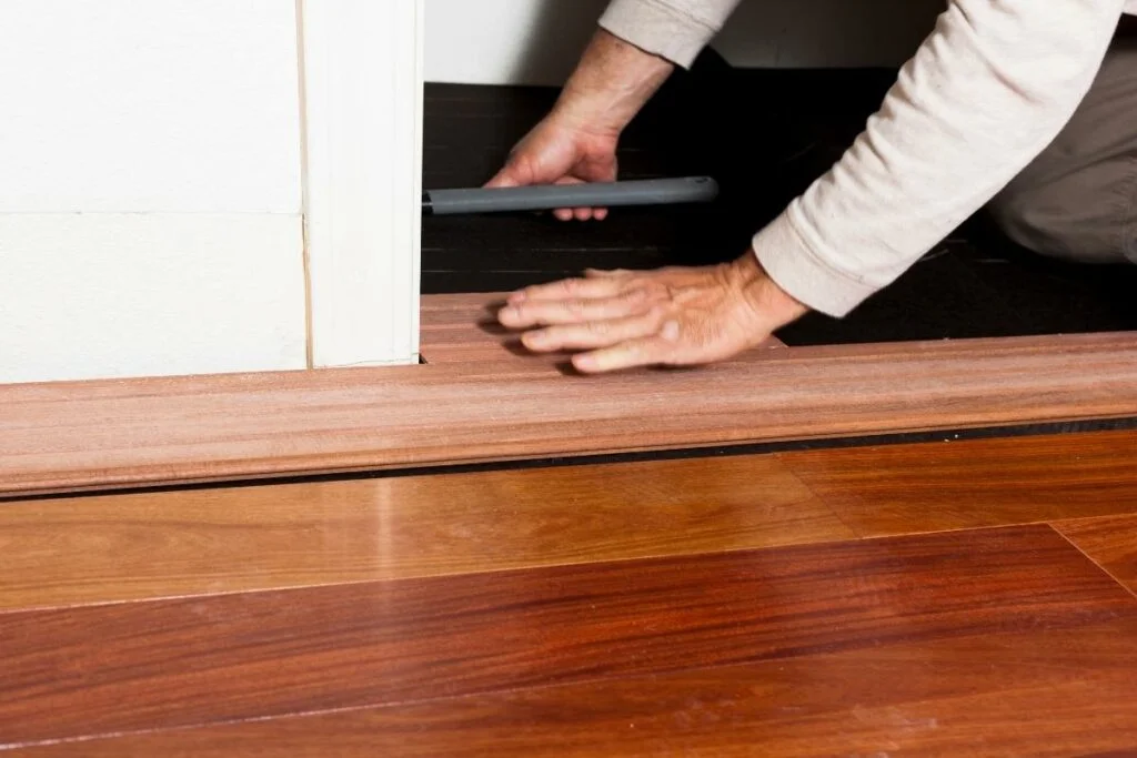 A man installing hardwood flooring.