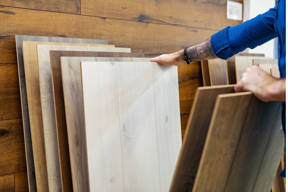 Person selecting innovative wooden floor samples from a collection.