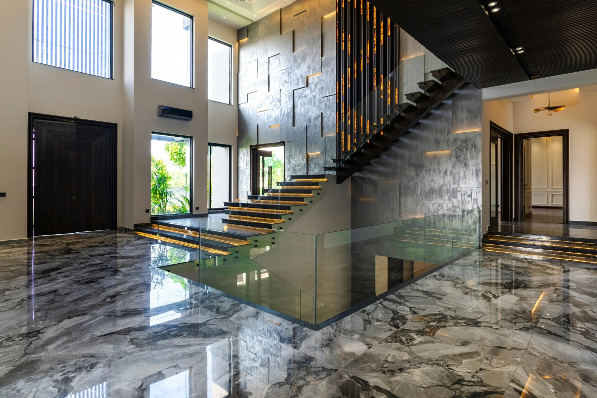 Luxury Home Flooring Ideas for Buckhead: Hardwood, Tile, and More 4 Modern interior with a floating staircase featuring illuminated steps, high ceilings, large windows, and polished marble luxury home flooring.