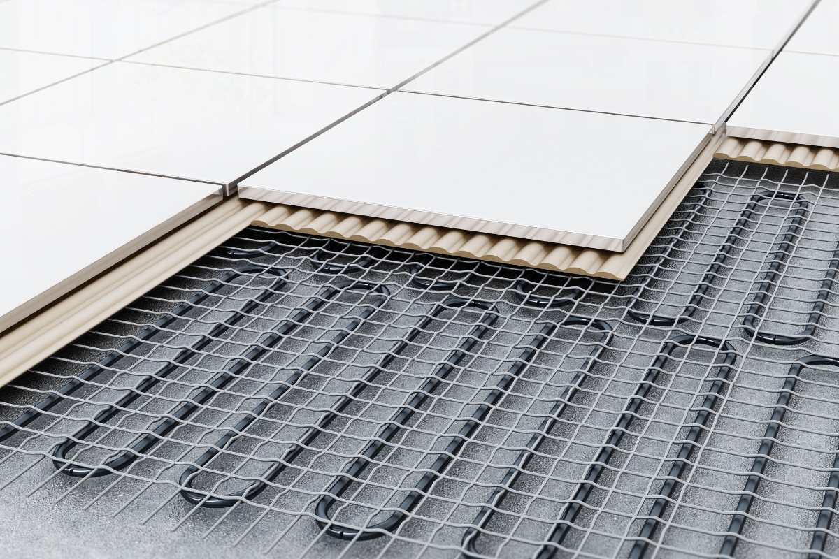 Luxury Home Flooring Ideas for Buckhead: Hardwood, Tile, and More 9 Cross-section showing luxury home flooring with white ceramic tiles installed over underfloor heating wires and a layer of adhesive on a subfloor.