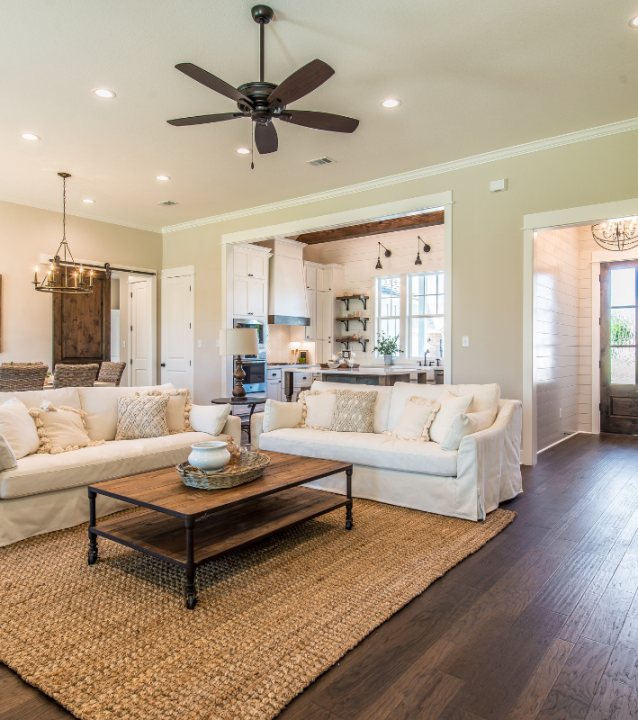 A living room with hardwood floors and a ceiling fan provided by Acworth Flooring Company.