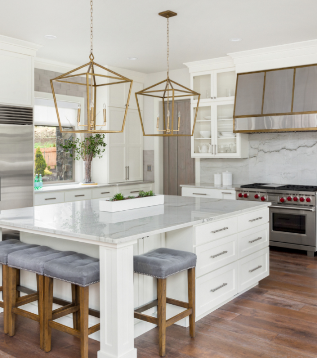 A white kitchen with a center island and bar stools, designed by Cartersville Flooring Company. A white kitchen with a center island and bar stools, designed by Cartersville Flooring Company.