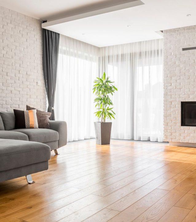 A living room with hardwood flooring and a fireplace.