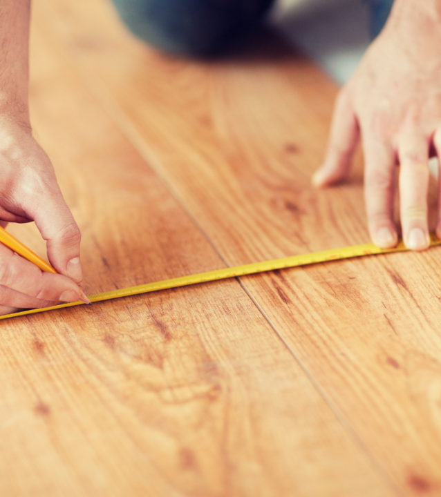 A man measuring a wooden floor for Smyrna Flooring Company. A man measuring a wooden floor for Smyrna Flooring Company.