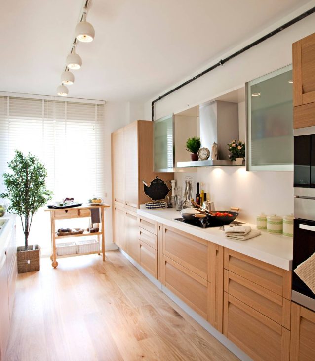 A kitchen with wooden cabinets and vinyl flooring.